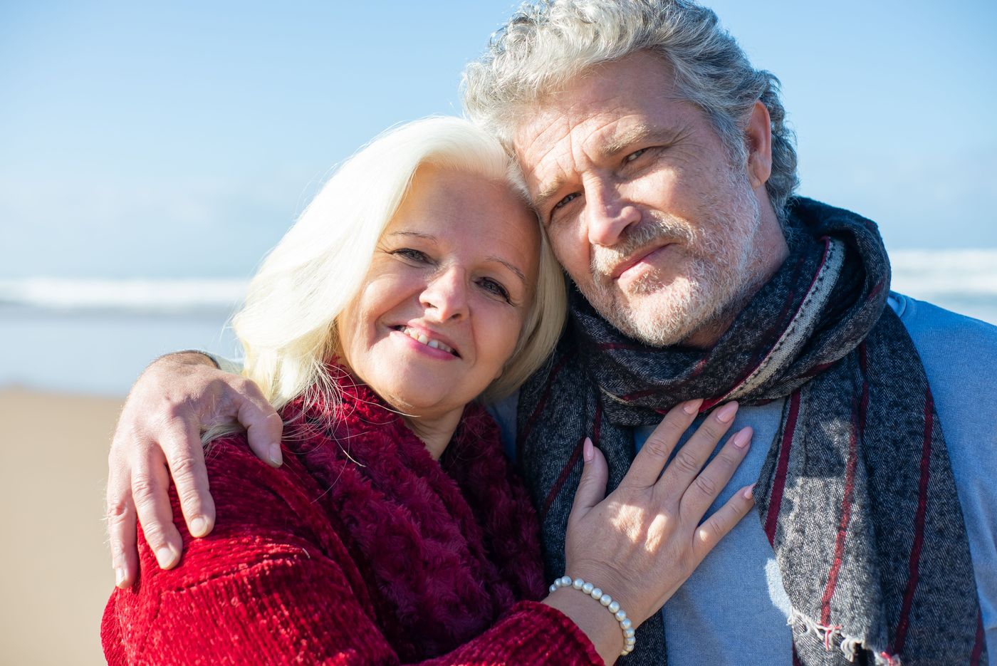 Mature couple smiling together on a sunny beach