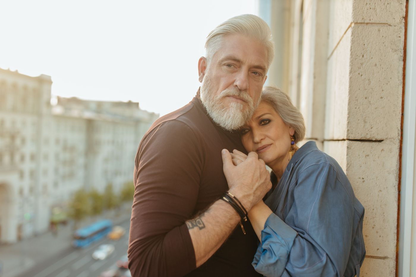 Stylish mature couple embracing on a city balcony